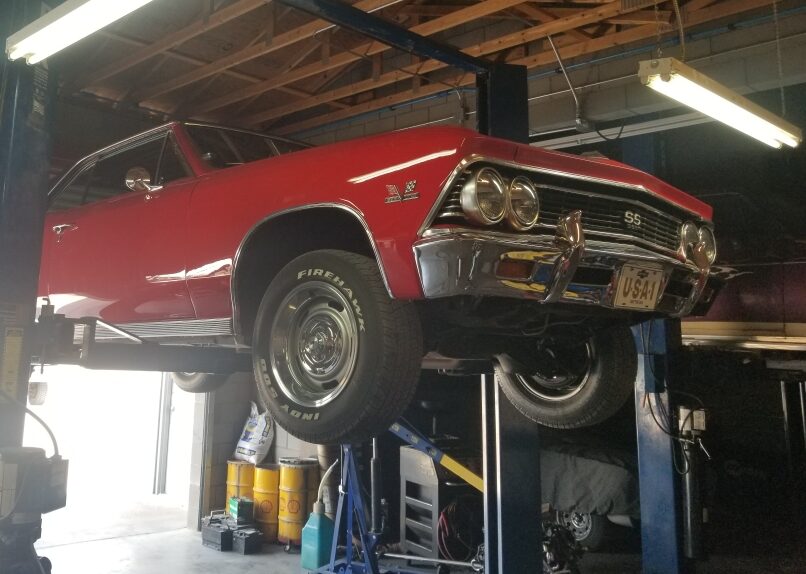 Red s1966 Chevy Chevelle on rack at Laveen Auto Works garage.